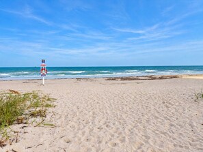Uma praia com posto de salva-vidas e vista para o oceano.