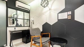Een moderne kamer met een bureau, stoel en een ronde tafel.