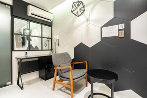 A modern room with a desk, chair, and round table.