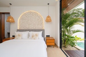 A modern bedroom with a large bed, two bedside tables, a unique textured wall, and a view of a pool. - Villa Serene by Pertama Stay (Ungasan)