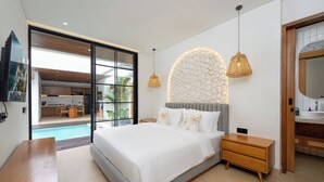 Une chambre moderne avec un grand lit, une table de chevet en bois, une lampe de chevet, une grande fenêtre et une vue sur la cuisine et la piscine.