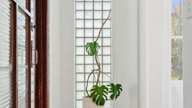 A hallway with wooden flooring, white walls, and a large window with blinds. - Belle Escapes - The Papilo (Holdfast Bay)