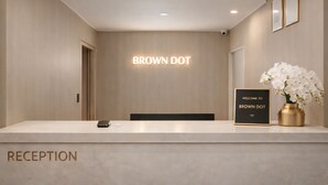 Ein Empfangsbereich mit einem Schild mit der Aufschrift 'BROWN DOT' und einem Willkommensschild.