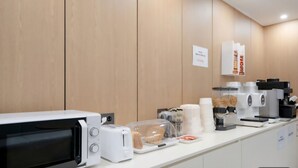 Eine Küchenzeile mit Mikrowelle, Toaster und Kaffeemaschine.