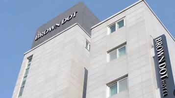 Ein modernes Hotelgebäude mit einem gut sichtbaren 'BROWN DOT HOTEL'-Schild an der Fassade.