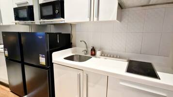 Appartement, balkon, uitzicht op stad | Privékeuken | Een koelkast, een magnetron, een kookplaat, kookgerei, borden en bestek