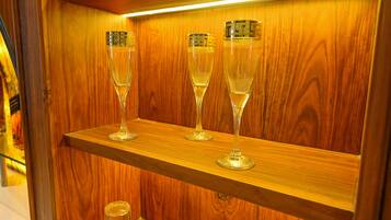 Three champagne flutes on a wooden shelf.