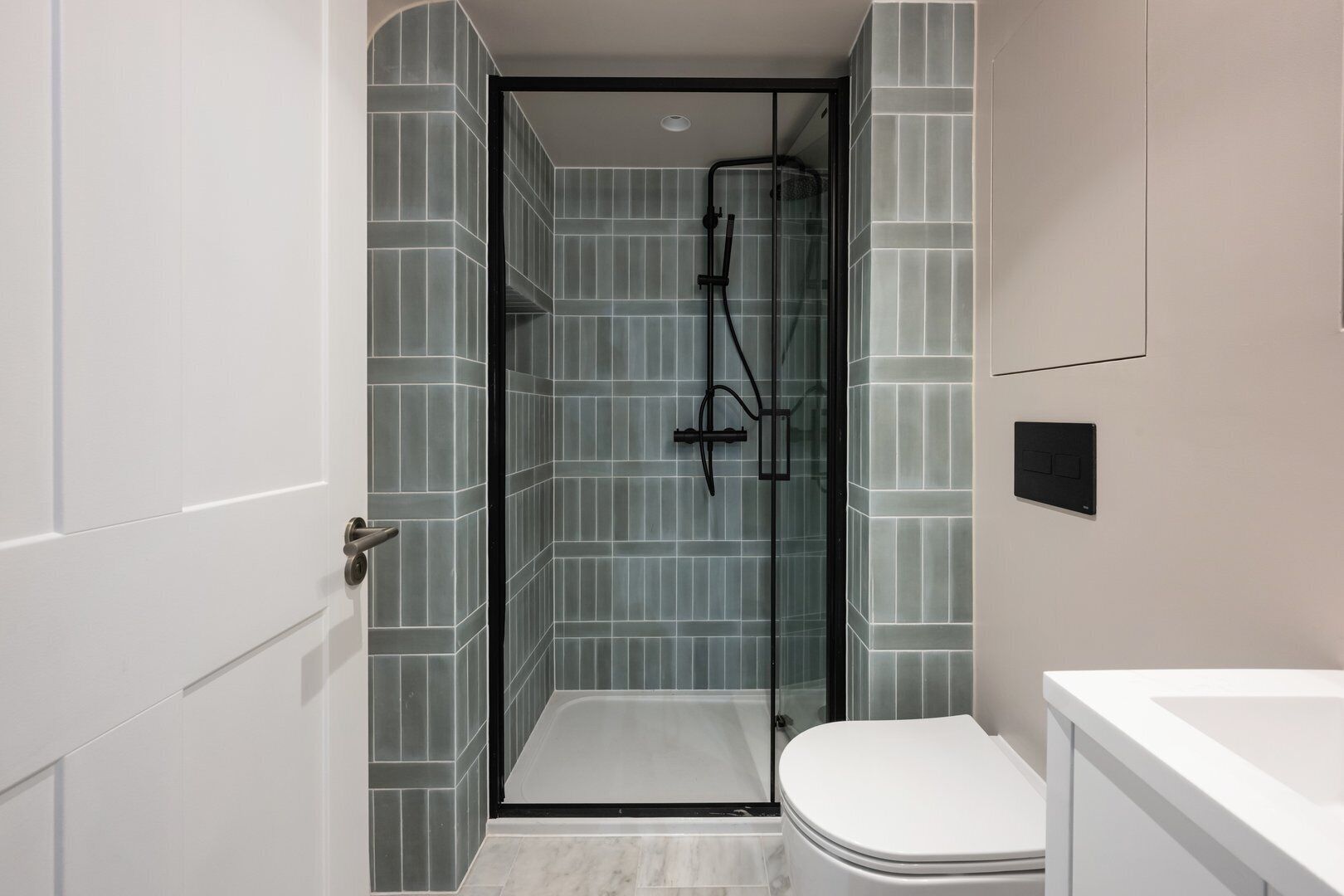 Un baño pequeño con ducha, inodoro y lavabo.