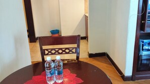 Uma mesa de jantar com duas garrafas de água e um jogo de mesa de renda vermelha.
