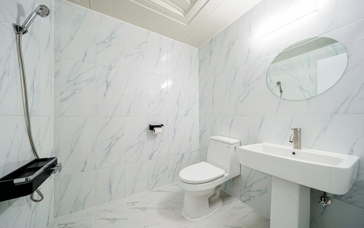 A bathroom with a toilet, a sink, and a shower.