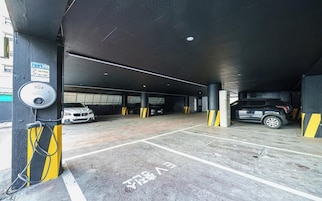 Un estacionamiento subterráneo con varios espacios, una cámara de seguridad y una estación de carga.