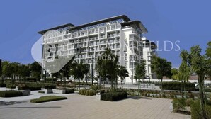 A modern multi-story hotel with a unique curved facade, surrounded by landscaped gardens and a paved walkway. - Bloomfileds Fabiouluxe Stu In Oasis (Abu Dhabi)