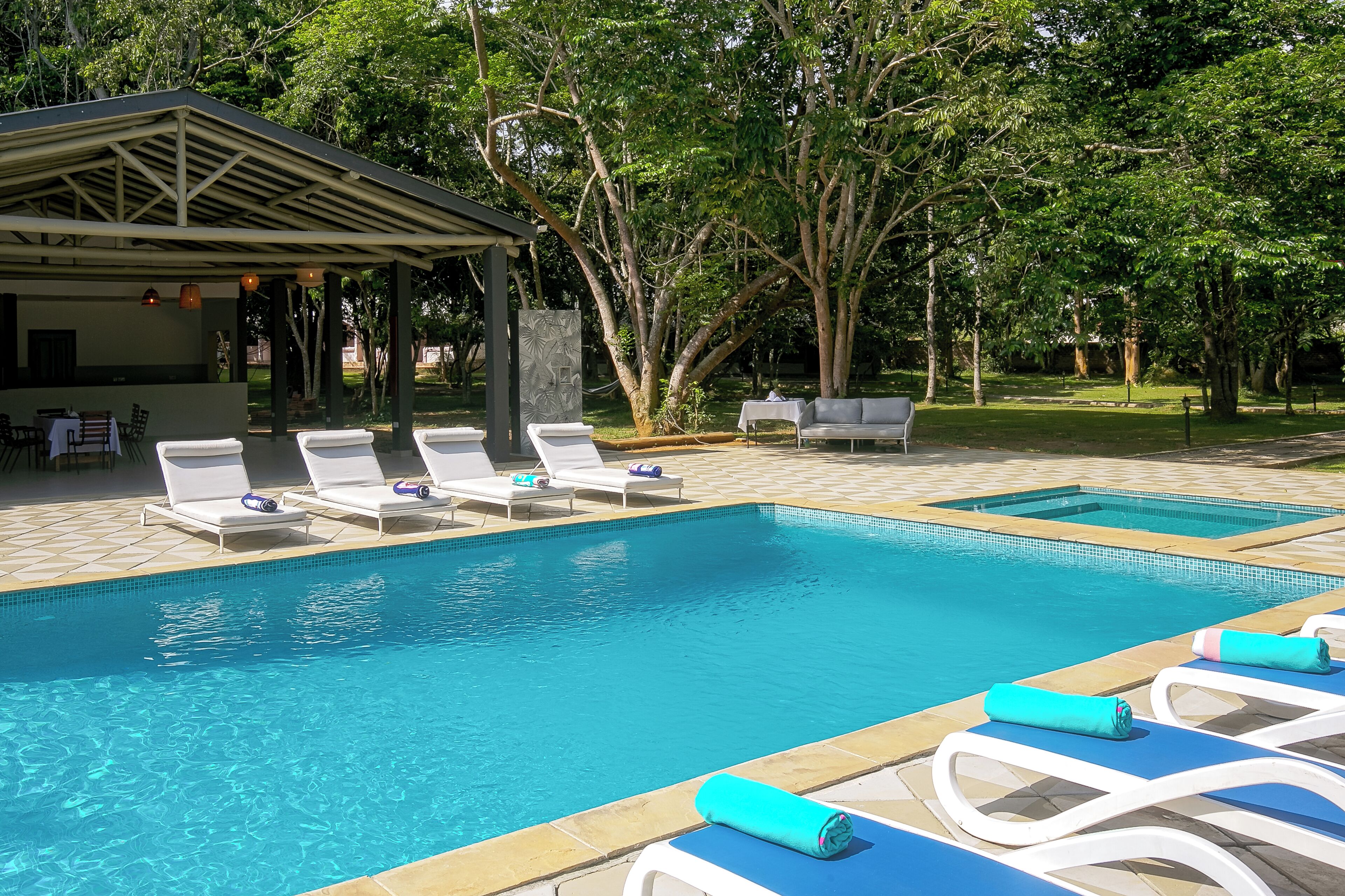 4 buitenzwembaden, ligstoelen bij het zwembad