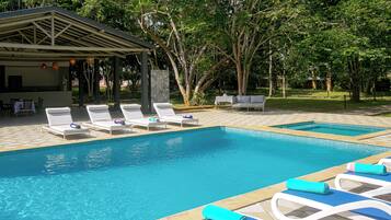 4 buitenzwembaden, ligstoelen bij het zwembad