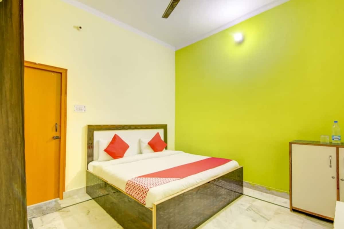 Une chambre d’hôtel avec un lit, une armoire et une porte.