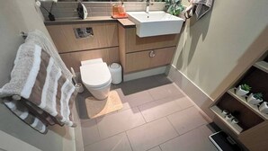 A modern bathroom with a toilet, sink, and towel rack. - Room-room in Melbourne CBD (Melbourne)