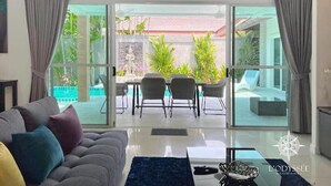 Ein modernes Wohnzimmer mit einer Couch, einem Couchtisch und einem Essbereich mit Stühlen und einem Tisch.