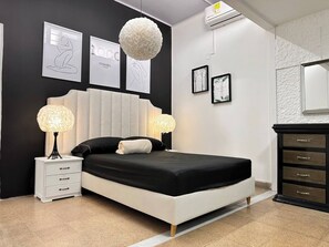 A modern bedroom with a large bed, two bedside lamps, a dresser, and framed artwork on the walls. - Group stay 21 guests,  WiFi 900 Mb (Medellín)