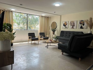A living room with a sofa, two armchairs, a coffee table, and a potted plant. - Group stay 21 guests,  WiFi 900 Mb (Medellín)