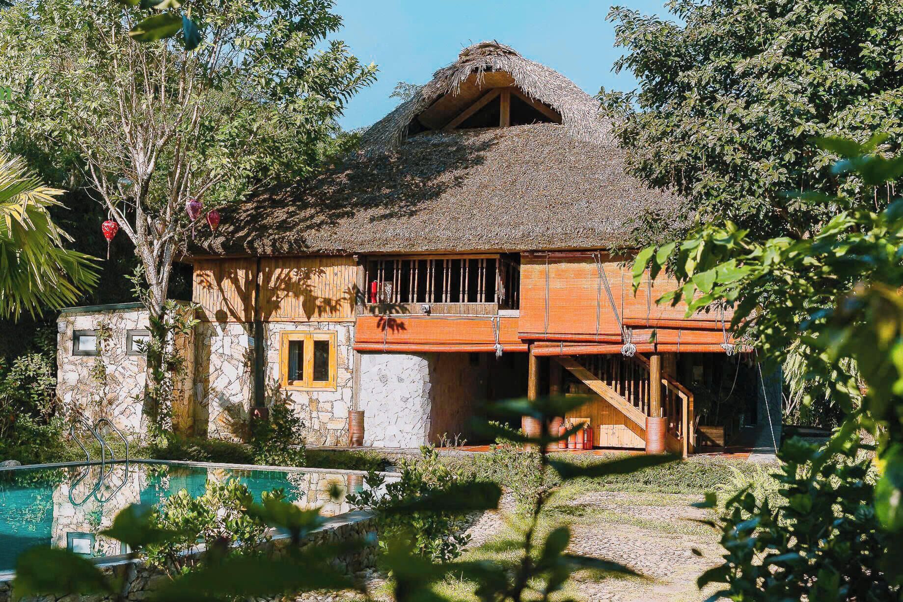 A rustic house with a thatched roof, wooden walls, and a small window.