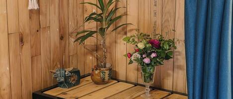 Pared de madera con una planta de bambú y un florero sobre una mesa.