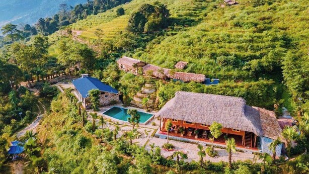 A hillside property with a pool, thatched-roof structures, and lush greenery. - TV Palm Ecolodge Ha Giang (Ha Giang 1)
