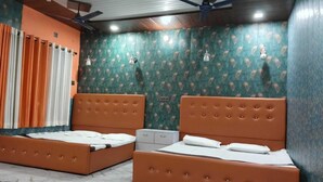 A room with two beds, each with a brown headboard, a marble-patterned floor, and a patterned green wall. - Fauzi Rasoi & Guest House (Faizabad)
