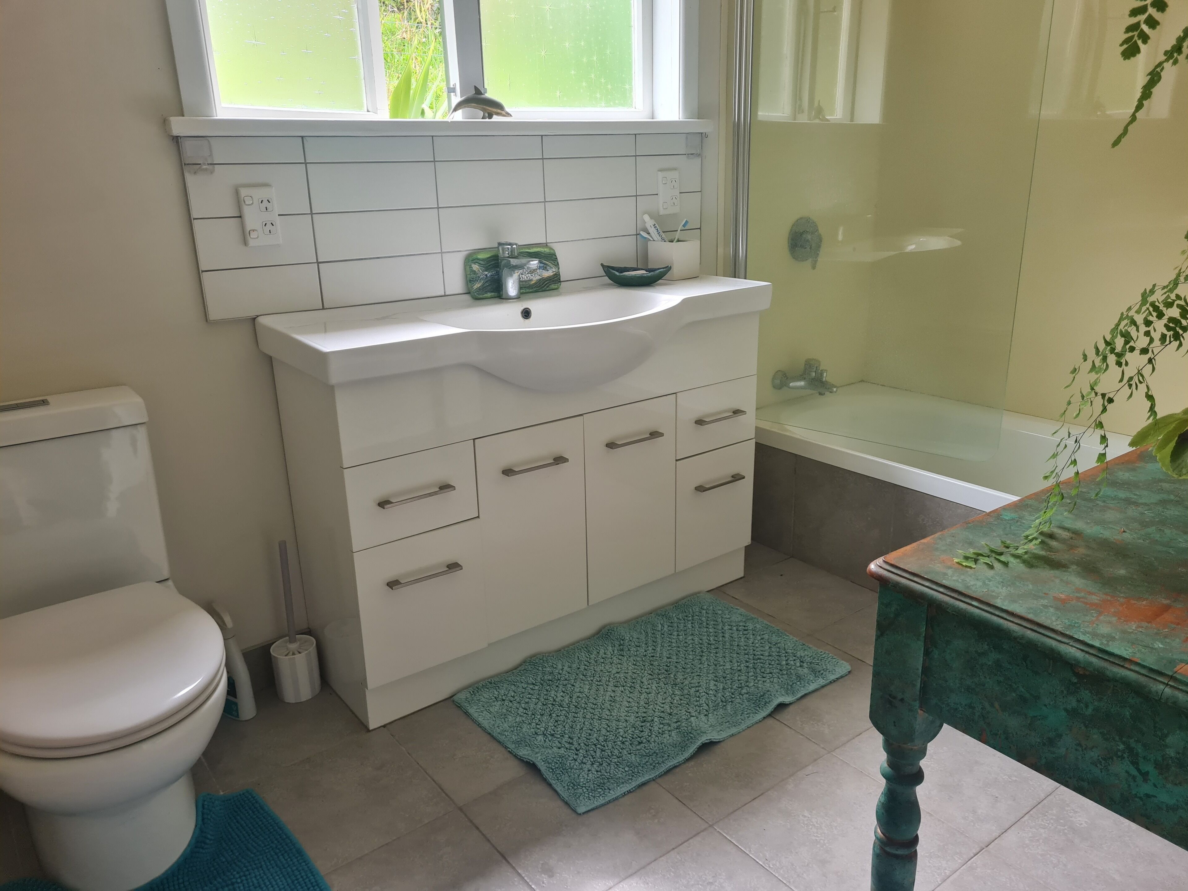 Een badkamer met toilet, wastafel en bad.