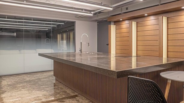 Una cocina moderna con una isla central, electrodomésticos de acero inoxidable y una pared de acento de madera.