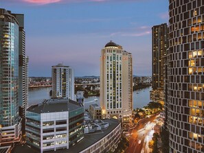 Stadsgezicht met wolkenkrabbers, een rivier en een brug.