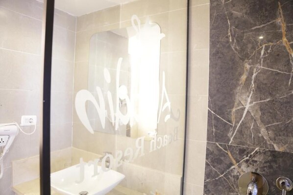 A bathroom with a glass partition, a sink, and a mirror. - Aladdin Beach Resort - Families and Couples Only (Hurghada)