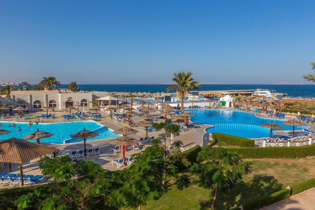 A resort with multiple swimming pools, sun loungers, and umbrellas.