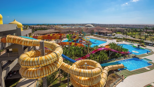 A resort with multiple water slides, a swimming pool, and a view of the surrounding landscape.
