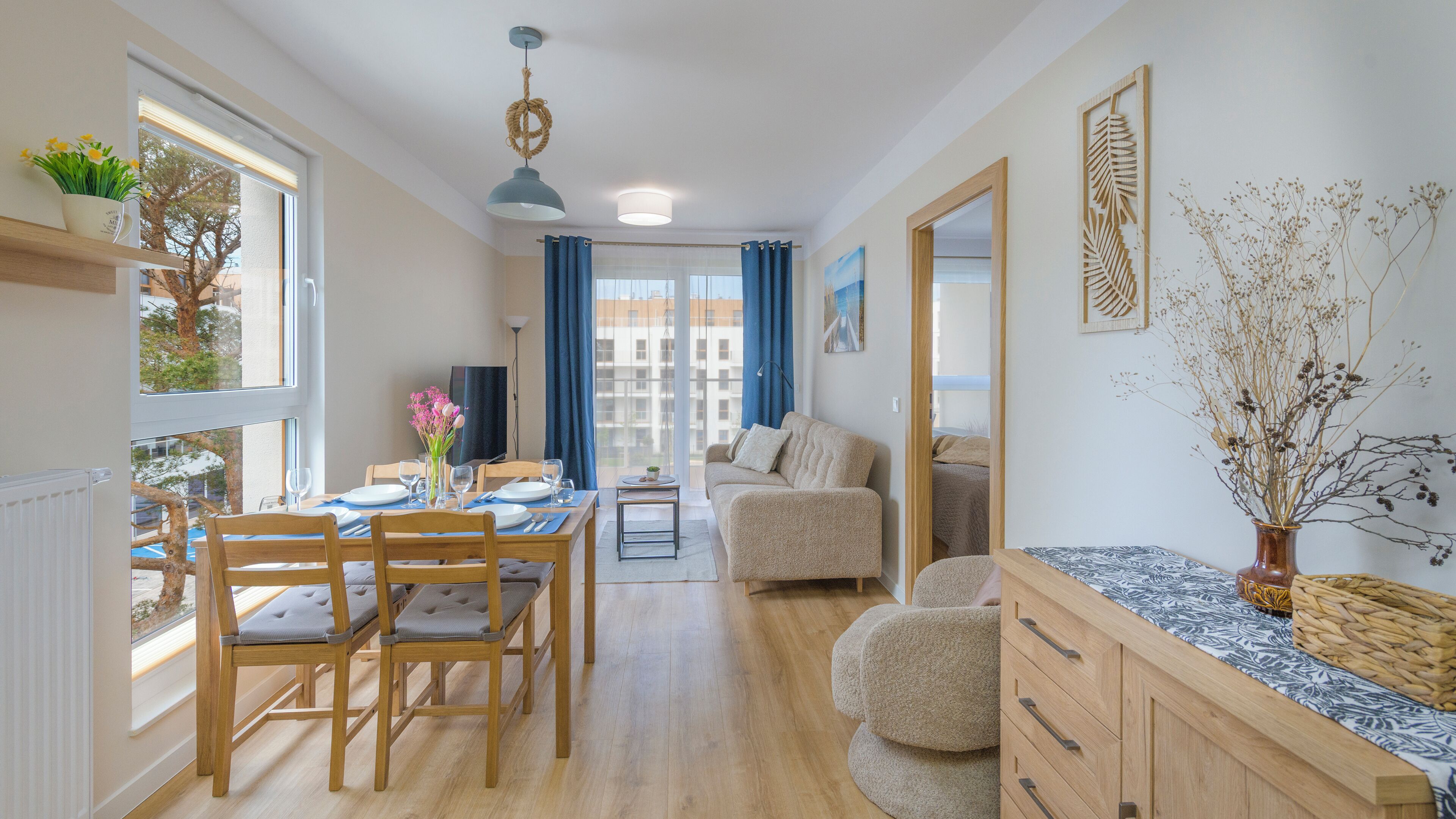 A modern apartment with a dining area, living space, and a kitchen.