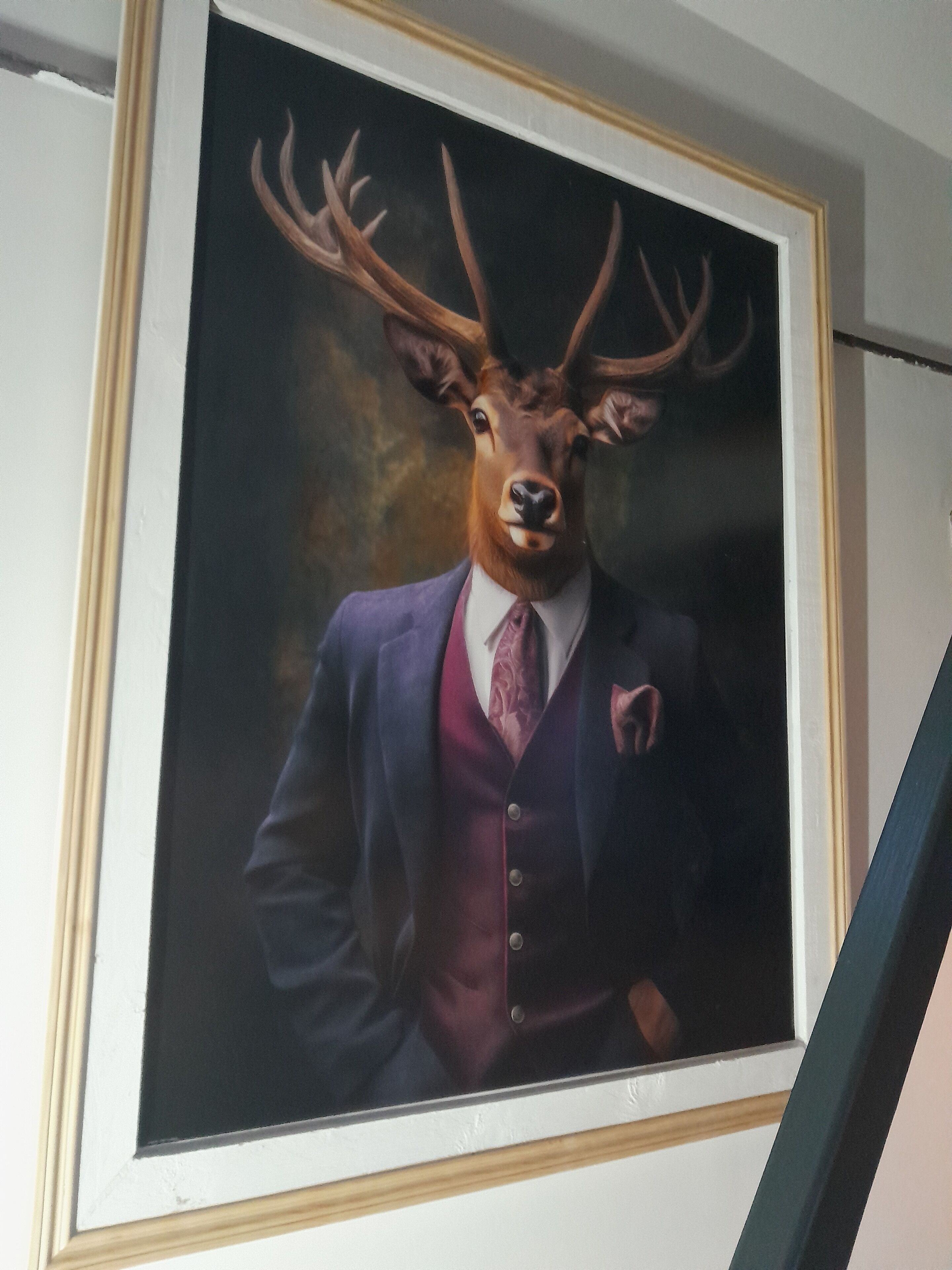 A framed portrait of a deer in a suit.