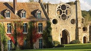 Un edificio histórico con fachada de piedra, múltiples ventanas y un gran ventanal circular.