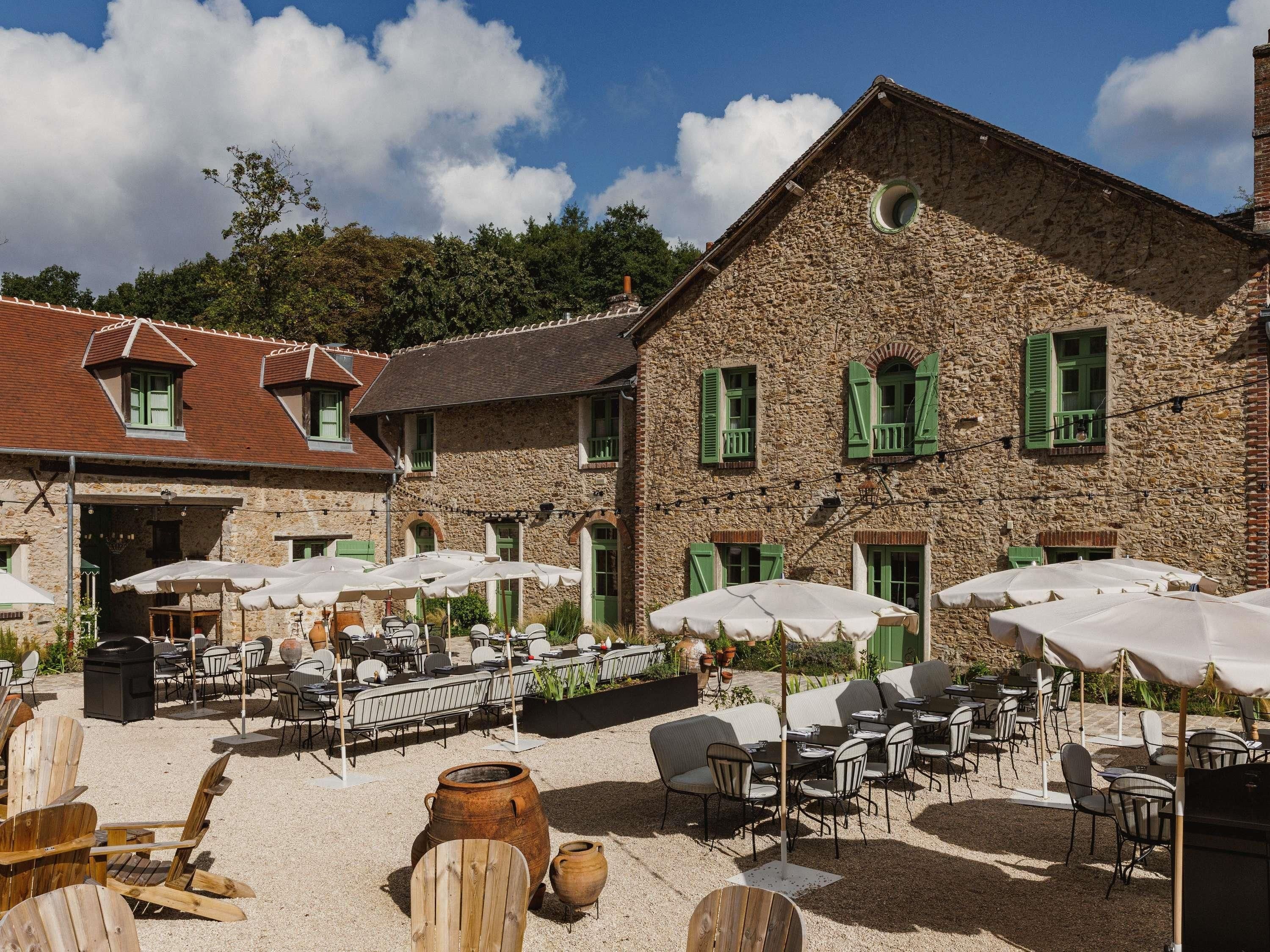 A stone building with outdoor seating and umbrellas.