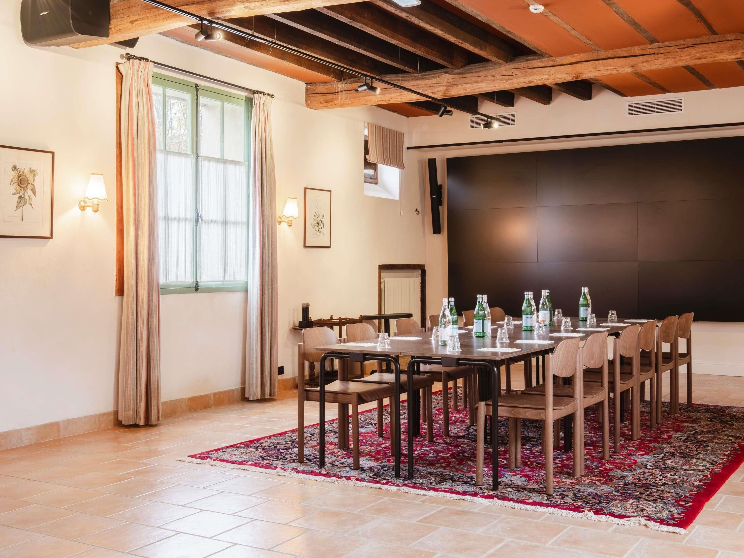 A conference room with a large table, chairs, and a projector screen.