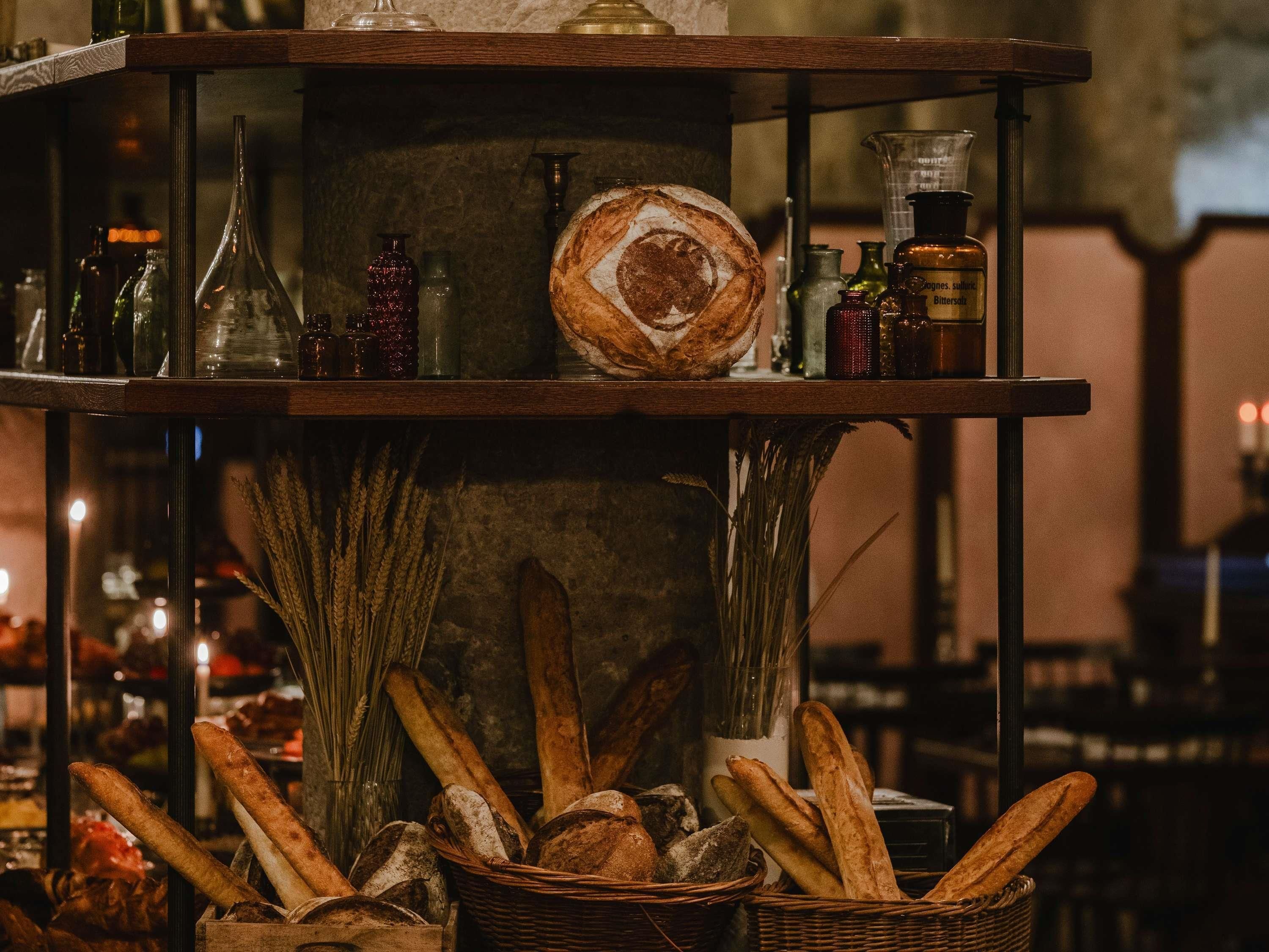 A multi-tiered display with bread, bottles, and a rustic ambiance.
