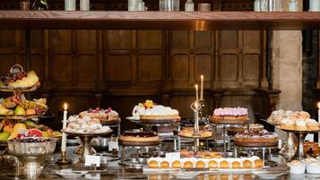 A buffet with various desserts and fruits.