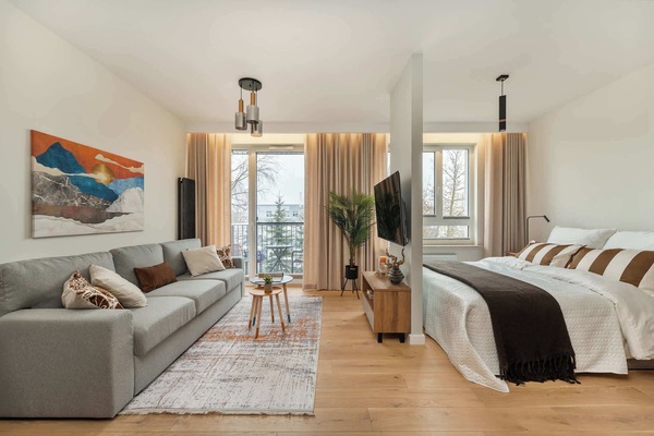 Bright living arStylish view of the studio showing the living area and the sleeping area in one open, well-designed space.ea with a comfortable sofa, coffee table, and direct access to the balcony. Large windows bring in plenty of natural light.