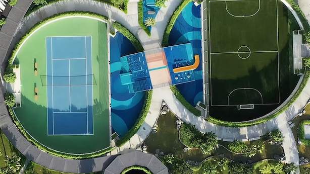 Vista aérea de un complejo deportivo con múltiples canchas de tenis, una piscina y una cancha de baloncesto.