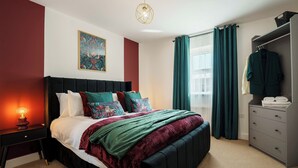 Une chambre à coucher moderne avec un grand lit, une table de chevet avec une lampe, une armoire et une fenêtre avec des rideaux.
