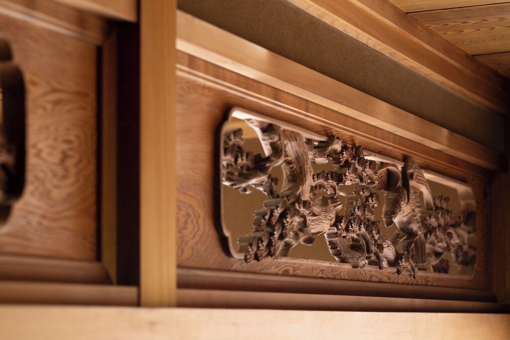 Un panel de madera tallada con gran detalle y un diseño intrincado, probablemente parte de la decoración de una habitación.