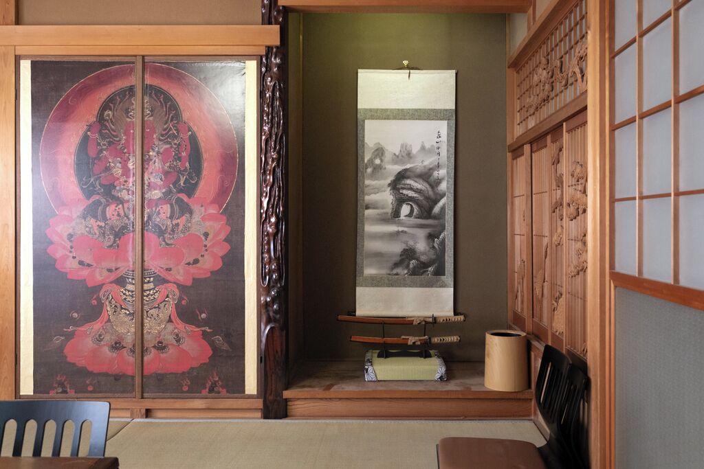 A traditional Japanese room with sliding doors, a tatami mat floor, and a shoji screen.