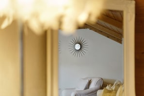 A room with a bed, a wall clock, and a wooden ceiling structure. - Apartment 'Bayernseele - Bayerwald' with Mountain View, Shared Garden and Wi-Fi (Spiegelau)