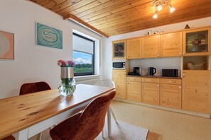 Una cocina con armarios de madera, una mesa de comedor y sillas.