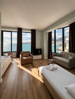 Habitación Deluxe, vistas al mar | Tabla de planchar con plancha y ropa de cama