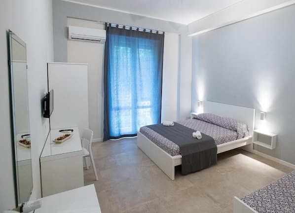 A modern bedroom with a bed, bedside tables, a desk, and a chair. - Le Stanze dell'Emiro (Palermo)