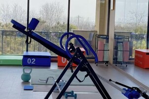 Un gimnasio con equipo de ejercicio, incluyendo una cinta de correr, pesas y una pesa rusa.